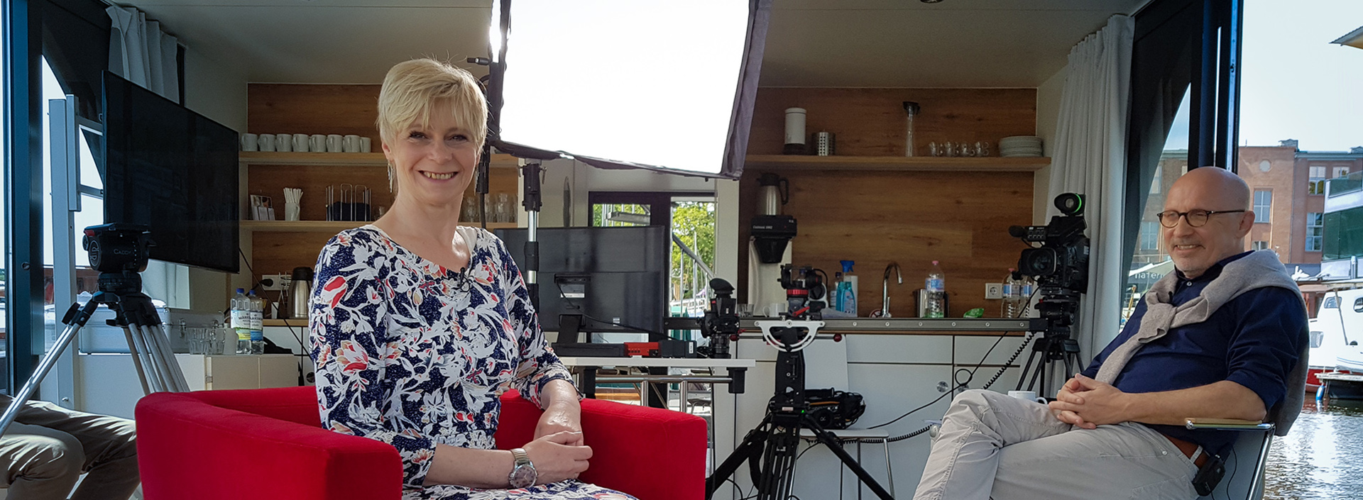 Tatjana Loose sitzt auf einem Hausboot im Roten Sessel für ein Interview