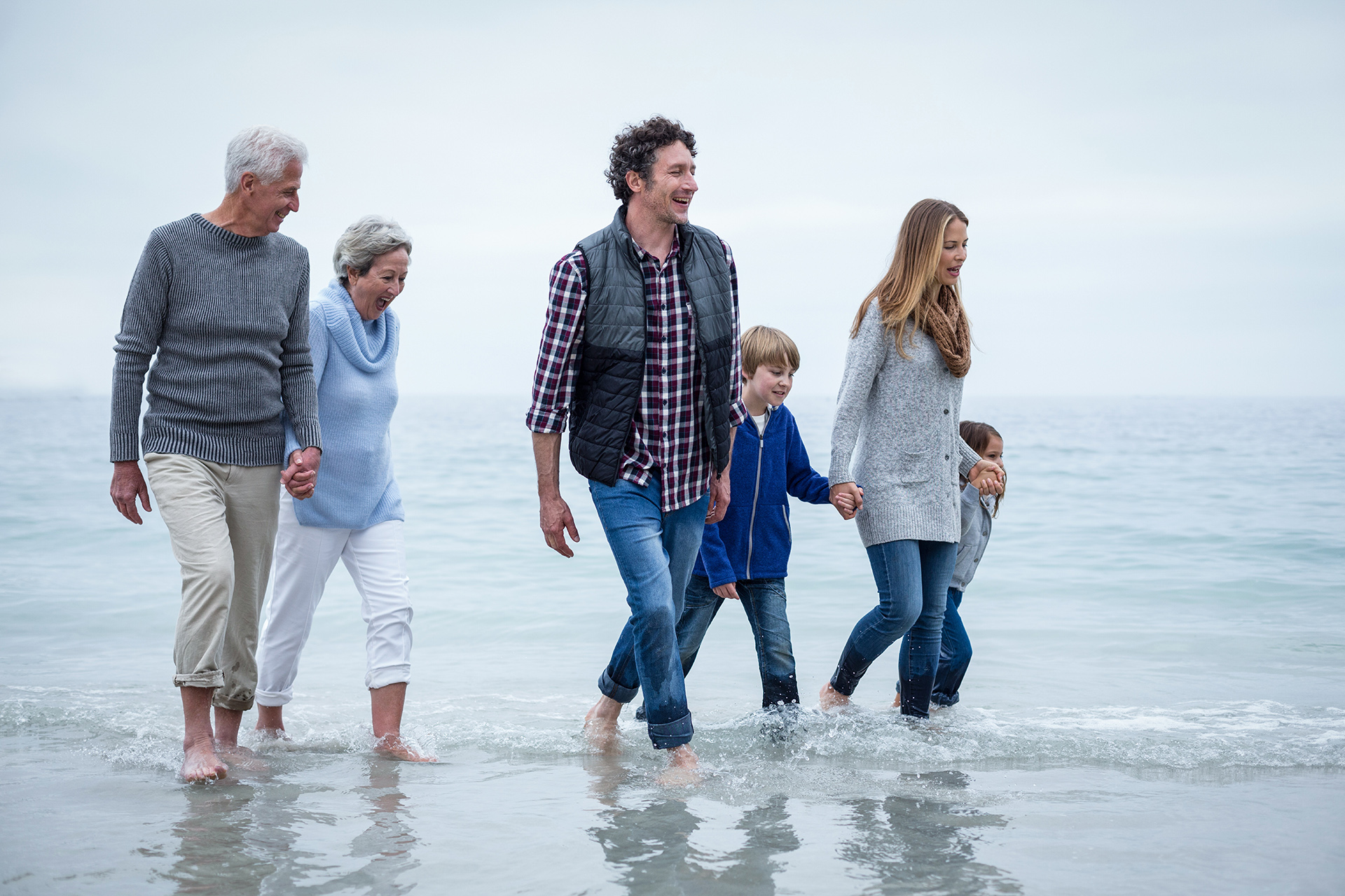 3-Generationen-Familie läuft am Strand
