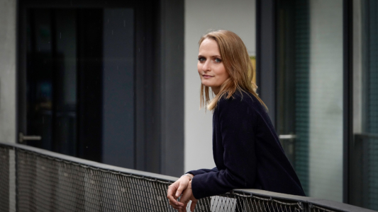 Marieke Steiner lehnt über einem Geländer und schaut verträumt in die Ferne