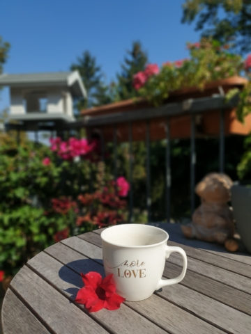Kaffeetasse im Garten auf dem Tisch mit der Aufschrift "LoveW"