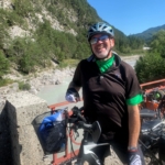Mann auf Mountainbike in den Bergen neben einem Gebirgsbach