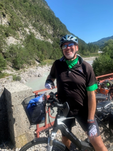 Mann auf Mountainbike in den Bergen neben einem Gebirgsbach
